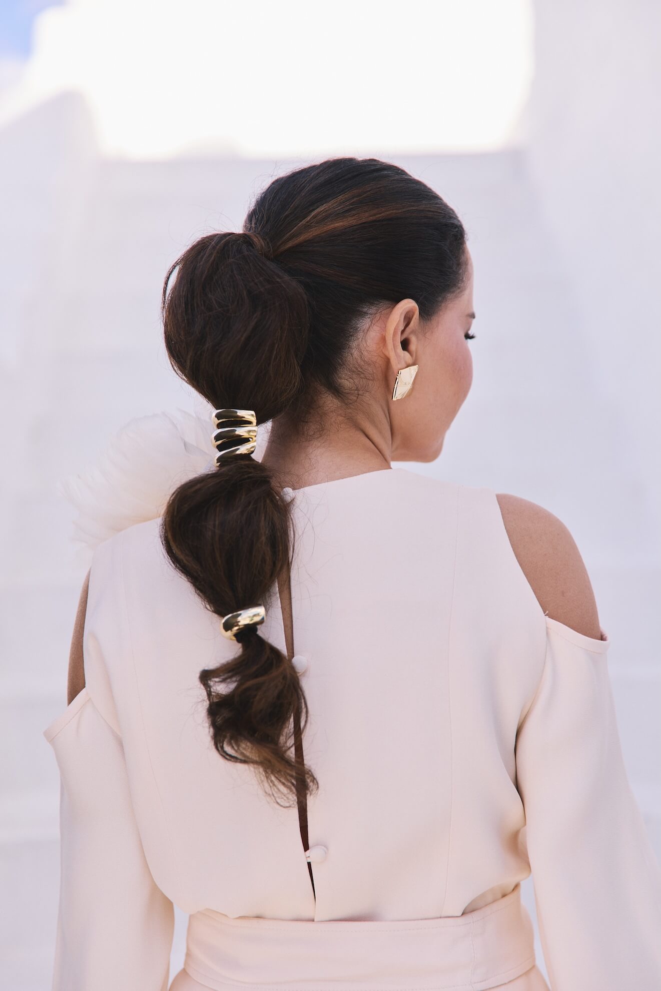 A Renata de costas mostrando os detalhes do vestido e das presilhas douradas no cabelo